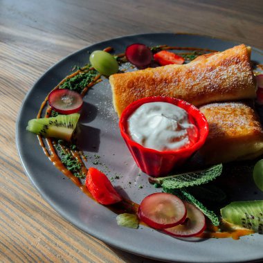 Tatlı soslu kızarmış krep ve egzotik meyveler. İnce krepli nefis kahvaltı.