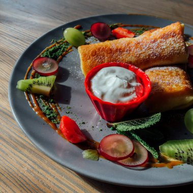 Tatlı soslu kızarmış krep ve egzotik meyveler. İnce krepli nefis kahvaltı.