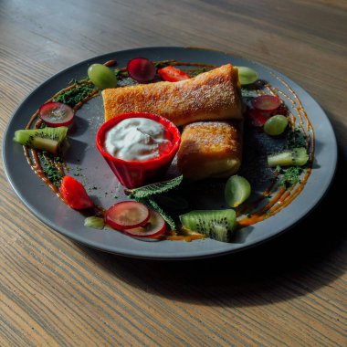 Tatlı soslu kızarmış krep ve egzotik meyveler. İnce krepli nefis kahvaltı.