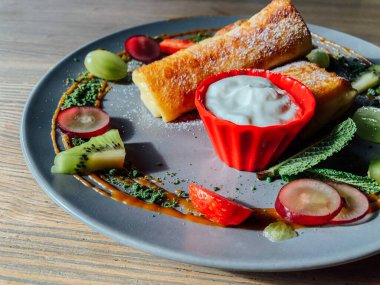 Tatlı soslu kızarmış krep ve egzotik meyveler. İnce krepli nefis kahvaltı.