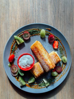 Tatlı soslu kızarmış krep ve egzotik meyveler. İnce krepli nefis kahvaltı.