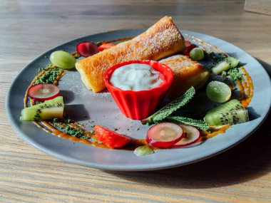 Tatlı soslu kızarmış krep ve egzotik meyveler. İnce krepli nefis kahvaltı.