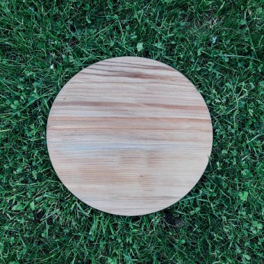 Yeşil çim arka planda yuvarlak ahşap tahta