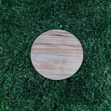 Yeşil çim arka planda yuvarlak ahşap tahta