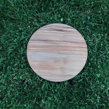 Yeşil çim arka planda yuvarlak ahşap tahta