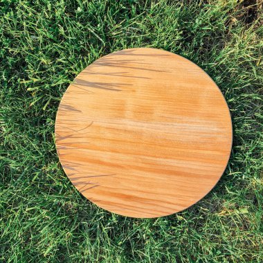 Yeşil çim arka planda yuvarlak ahşap tahta