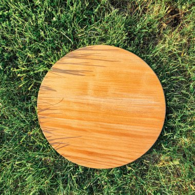 Yeşil çim arka planda yuvarlak ahşap tahta