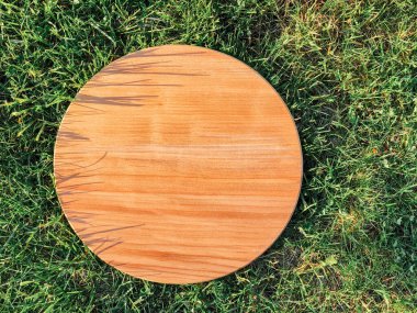 Yeşil çim arka planda yuvarlak ahşap tahta