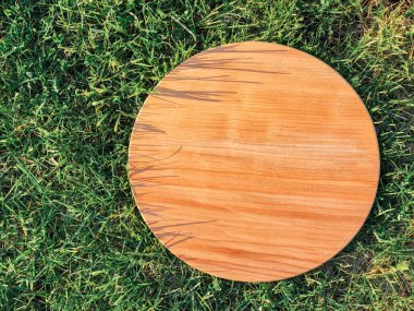 Yeşil çim arka planda yuvarlak ahşap tahta