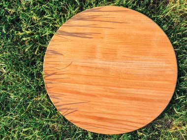 Yeşil çim arka planda yuvarlak ahşap tahta