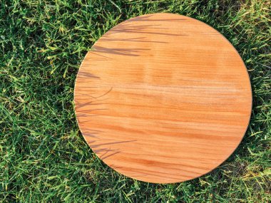 Yeşil çim arka planda yuvarlak ahşap tahta