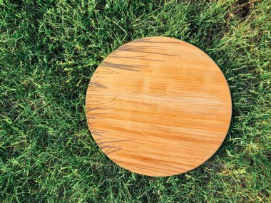 Yeşil çim arka planda yuvarlak ahşap tahta