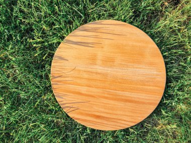 Yeşil çim arka planda yuvarlak ahşap tahta