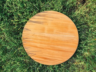 Yeşil çim arka planda yuvarlak ahşap tahta