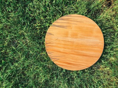 Yeşil çim arka planda yuvarlak ahşap tahta