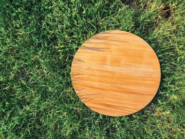 Yeşil çim arka planda yuvarlak ahşap tahta