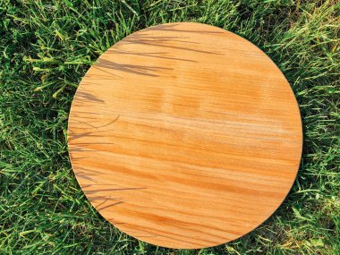 Yeşil çim arka planda yuvarlak ahşap tahta