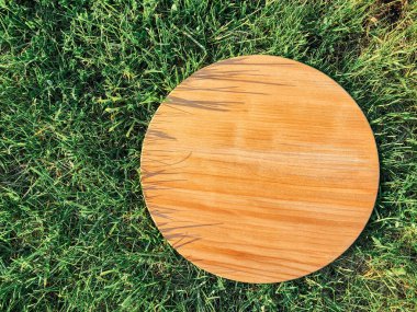 Yeşil çim arka planda yuvarlak ahşap tahta