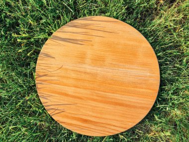 Yeşil çim arka planda yuvarlak ahşap tahta