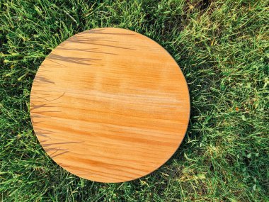 Yeşil çim arka planda yuvarlak ahşap tahta