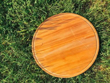 Yeşil çim arka planda yuvarlak ahşap tahta