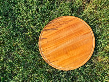 Yeşil çim arka planda yuvarlak ahşap tahta