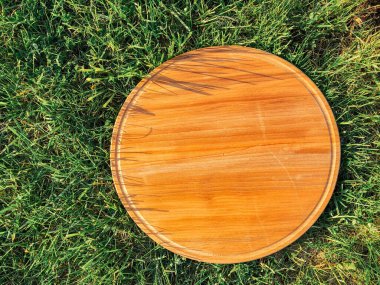 Yeşil çim arka planda yuvarlak ahşap tahta