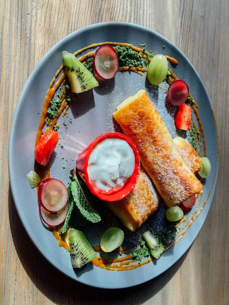 Tatlı soslu kızarmış krep ve egzotik meyveler. İnce krepli nefis kahvaltı.