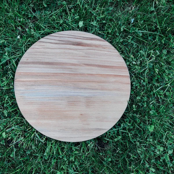 Yeşil çim arka planda yuvarlak ahşap tahta