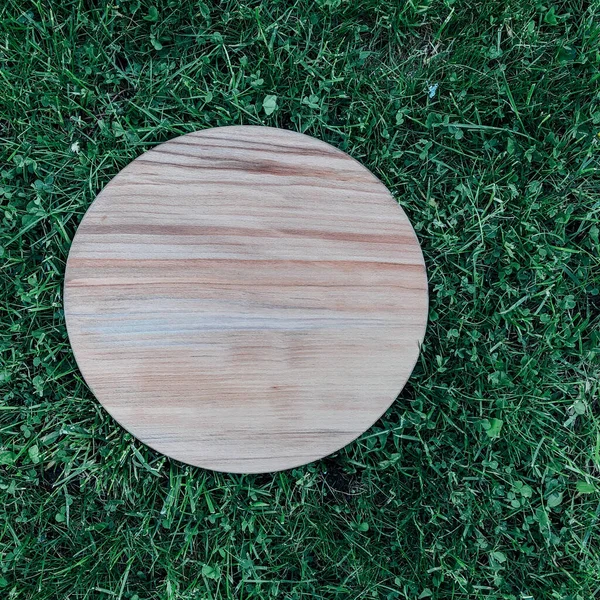 Yeşil çim arka planda yuvarlak ahşap tahta