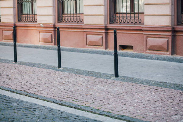 Paving stones with iron poles at walking path in park 