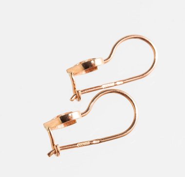 Beyaz arka planda izole edilmiş bir çift altın küpe.