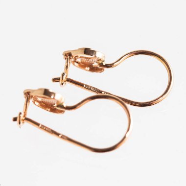 Beyaz arka planda izole edilmiş bir çift altın küpe.