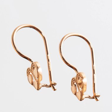 Beyaz arka planda izole edilmiş bir çift altın küpe.