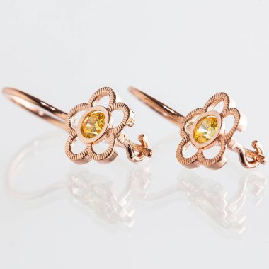 Beyaz arka planda izole edilmiş bir çift altın küpe.