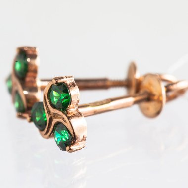 Beyaz arka planda izole edilmiş bir çift altın küpe.