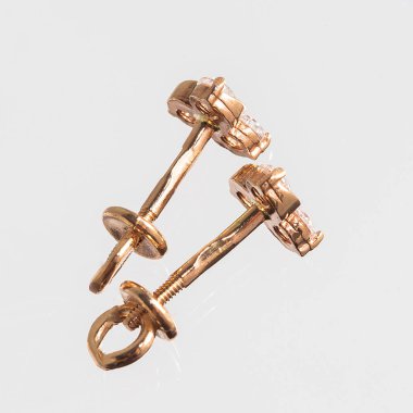 Beyaz arka planda izole edilmiş bir çift altın küpe.