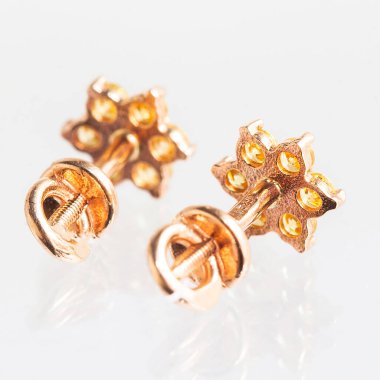 Beyaz arka planda izole edilmiş bir çift altın küpe.