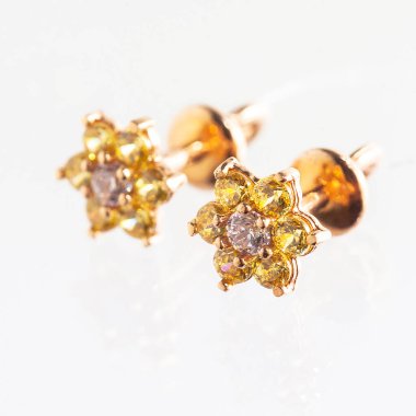 Beyaz arka planda izole edilmiş bir çift altın küpe.