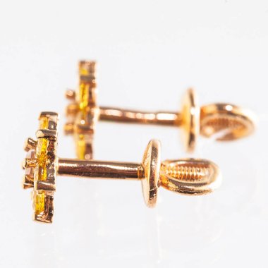 Beyaz arka planda izole edilmiş bir çift altın küpe.