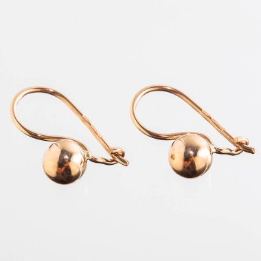 Beyaz arka planda izole edilmiş bir çift altın küpe.