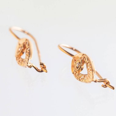 Beyaz arka planda izole edilmiş bir çift altın küpe.