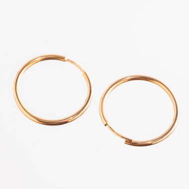 Beyaz arka planda izole edilmiş bir çift altın küpe.