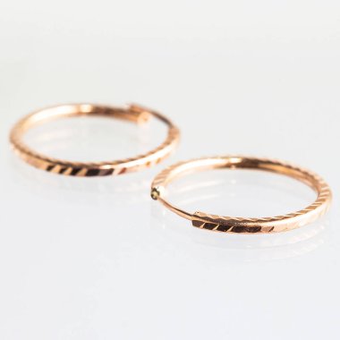 Beyaz arka planda izole edilmiş bir çift altın küpe.