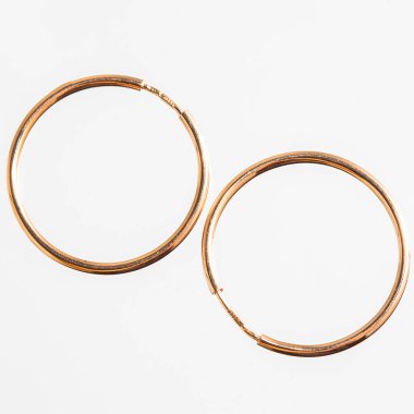 Beyaz arka planda izole edilmiş bir çift altın küpe.