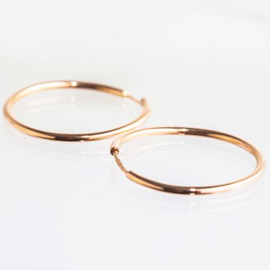 Beyaz arka planda izole edilmiş bir çift altın küpe.