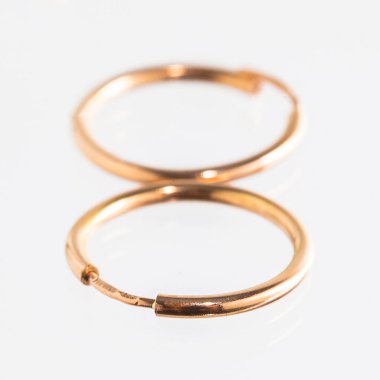 Beyaz arka planda izole edilmiş bir çift altın küpe.