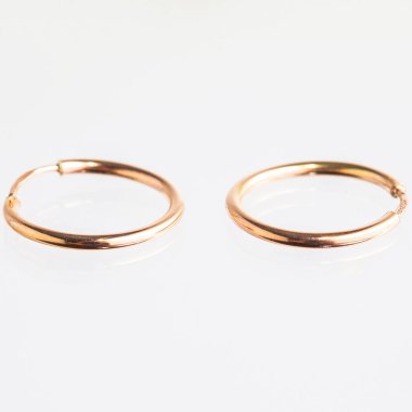 Beyaz arka planda izole edilmiş bir çift altın küpe.