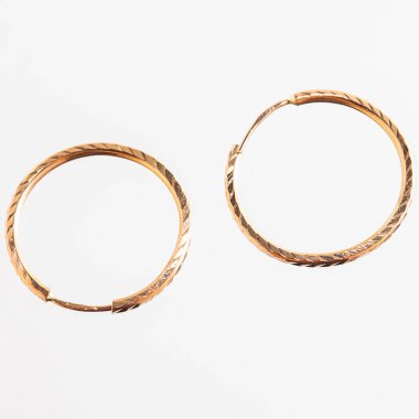 Beyaz arka planda izole edilmiş bir çift altın küpe.