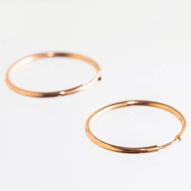 Beyaz arka planda izole edilmiş bir çift altın küpe.